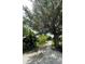 Gravel driveway lined with lush trees leading up to the home, creating a private and scenic entrance at 5727 Beechwood St, Punta Gorda, FL 33982