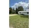 Quaint white home exterior with a well-maintained lawn, offering a charming and inviting curb appeal at 5727 Beechwood St, Punta Gorda, FL 33982