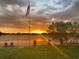 Beautiful waterfront sunset view with dock, chairs, and American flag, creating a serene ambiance at 5727 Beechwood St, Punta Gorda, FL 33982