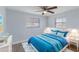 Bedroom with blue bedding, ceiling fan, and natural light at 711 Forest Hill Nw Ln, Port Charlotte, FL 33948