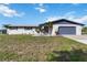 Charming single-story home with a well-kept lawn, nice landscaping, and a blue accent trim at 711 Forest Hill Nw Ln, Port Charlotte, FL 33948