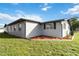 Well-maintained home exterior with fresh landscaping and a manicured lawn with mulched flower beds at 711 Forest Hill Nw Ln, Port Charlotte, FL 33948