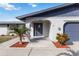 Inviting front entrance with a decorative glass door, arched entryway, and tropical landscaping at 711 Forest Hill Nw Ln, Port Charlotte, FL 33948