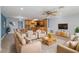 Open-concept living room featuring comfortable seating, a modern ceiling fan, and a seamless flow into the kitchen at 711 Forest Hill Nw Ln, Port Charlotte, FL 33948