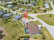An aerial view shows the home's location in a tranquil neighborhood with lush greenery and a nearby pool at 7334 N Tulip Tree, Punta Gorda, FL 33955