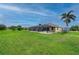 Sprawling backyard with a screened pool, mature trees, and lush green grass, perfect for outdoor living at 7512 Pon Kan, Punta Gorda, FL 33955