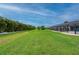 Extensive backyard featuring a well-maintained lawn, tropical foliage, and a screened-in lanai at 7512 Pon Kan, Punta Gorda, FL 33955