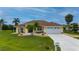 Charming single-story home with lush lawn, palm trees, front garden, and driveway with mailbox at 7512 Pon Kan, Punta Gorda, FL 33955