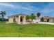A charming single-story home featuring a lush green lawn, desert landscaping, and a spacious driveway leading to a two-car garage at 7512 Pon Kan, Punta Gorda, FL 33955
