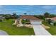 Inviting single-story home with a well-manicured lawn, palm trees, and a spacious driveway leading to an attached two-car garage at 7512 Pon Kan, Punta Gorda, FL 33955