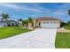 Charming one-story home with a two-car garage, complemented by palm trees and a green lawn at 7512 Pon Kan, Punta Gorda, FL 33955