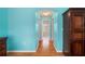 Hallway with hardwood floors and turquoise walls leads to other rooms in the house at 7512 Pon Kan, Punta Gorda, FL 33955