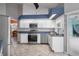 Modern kitchen with white cabinets, stainless appliances, and access to the outdoor patio and dining area at 7512 Pon Kan, Punta Gorda, FL 33955