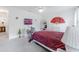 Bright bedroom features neutral walls, TV, and decorated with red fan and wicker furniture at 7652 Mikasa Dr, Punta Gorda, FL 33950
