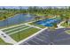 Aerial view of community bocce ball court, parking area, tennis courts, and lush landscaping in a serene setting at 7652 Mikasa Dr, Punta Gorda, FL 33950