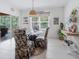 Cozy dining area with large windows, a glass table, and decorative chairs, adjacent to the outdoor patio at 7652 Mikasa Dr, Punta Gorda, FL 33950