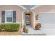 A front entry featuring a screen door, covered entry, and mature landscaping at 7652 Mikasa Dr, Punta Gorda, FL 33950