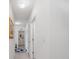 Long bright hallway with tile floor leading to various rooms of the home at 7652 Mikasa Dr, Punta Gorda, FL 33950