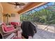 Screened patio features a grill, ceiling fan, and wicker furniture, creating a comfortable outdoor living space at 7652 Mikasa Dr, Punta Gorda, FL 33950
