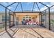 Expansive screened patio with tile flooring, comfortable seating, and a grill, perfect for outdoor gatherings at 7652 Mikasa Dr, Punta Gorda, FL 33950