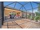 Spacious screened patio with plenty of seating, a grill, and durable flooring, ideal for outdoor living at 7652 Mikasa Dr, Punta Gorda, FL 33950