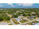 An aerial view showcases a well-maintained home in a lush, green neighborhood with mature trees at 891 Bayard St, Port Charlotte, FL 33948