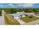 An aerial view of a well-maintained home nestled in a lush, green neighborhood with mature trees at 891 Bayard St, Port Charlotte, FL 33948