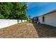 A spacious backyard featuring white fencing, a storage shed, and the rear of the screened-in lanai at 891 Bayard St, Port Charlotte, FL 33948