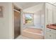 Bathroom featuring a glass enclosed shower, soaking tub, white tile, and a window with a view at 891 Bayard St, Port Charlotte, FL 33948