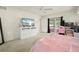 Bright bedroom featuring a ceiling fan, television, and access to a patio with a pink inflatable pool at 891 Bayard St, Port Charlotte, FL 33948