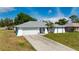 Charming single-story home featuring a well-maintained lawn, arched entryway, and attached two-car garage at 891 Bayard St, Port Charlotte, FL 33948