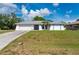 Charming single-story home featuring a two-car garage, and tropical landscaping in a well-maintained lawn at 891 Bayard St, Port Charlotte, FL 33948