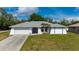 Charming single-story home featuring a two-car garage, and tropical landscaping in a well-maintained lawn at 891 Bayard St, Port Charlotte, FL 33948