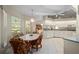 Spacious eat-in kitchen with a view of the screened-in lanai featuring white cabinetry, tile floors, and casual dining at 891 Bayard St, Port Charlotte, FL 33948
