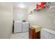 Functional laundry room with washer, dryer, overhead shelving, and storage; perfect for efficient chores at 891 Bayard St, Port Charlotte, FL 33948
