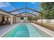 Sparkling in-ground pool within screened enclosure; featuring a spacious deck and comfortable lounge areas at 891 Bayard St, Port Charlotte, FL 33948