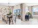 Elegant dining room with a modern chandelier, sleek table setting, and a view of the outdoor space at 9710 Sand Dune Ln, Punta Gorda, FL 33950