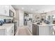 Modern kitchen features stainless steel appliances, white cabinetry, and a breakfast bar overlooking the dining area at 9710 Sand Dune Ln, Punta Gorda, FL 33950