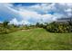 Expansive backyard with lush green lawn and mature landscaping, perfect for outdoor activities and relaxation at 1 Sportsman Cir, Rotonda West, FL 33947