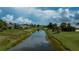 Scenic backyard view featuring a serene canal, green landscaping, and neighboring houses at 1 Sportsman Cir, Rotonda West, FL 33947
