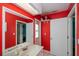 Bathroom highlighting the red walls, bright lighting, and linen shelves at 1 Sportsman Cir, Rotonda West, FL 33947