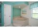 Bright bathroom featuring a corner soaking tub, a door and blue accents at 1 Sportsman Cir, Rotonda West, FL 33947