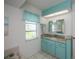Light and bright bathroom features marble countertops and a blue cabinet at 1 Sportsman Cir, Rotonda West, FL 33947