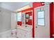 Fresh red bathroom featuring a sink, toilet, bath/shower combo, and a door leading outside at 1 Sportsman Cir, Rotonda West, FL 33947