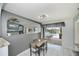 Bright dining area with white tile floors, a gray accent wall, and a view of the outdoor pool at 1 Sportsman Cir, Rotonda West, FL 33947