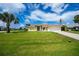 Welcoming single-Gathering home featuring a manicured lawn, palm trees, and decorative lawn ornaments at 1 Sportsman Cir, Rotonda West, FL 33947