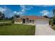 Inviting home featuring a well-manicured lawn, decorative fountain, and a spacious two-car garage at 1 Sportsman Cir, Rotonda West, FL 33947