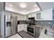 Modern kitchen with stainless steel appliances, granite counters, and white cabinetry with black hardware at 1 Sportsman Cir, Rotonda West, FL 33947
