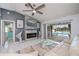 Light-filled living room with fireplace, ceiling fan, TV, and view to the pool at 1 Sportsman Cir, Rotonda West, FL 33947