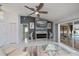 Bright living room featuring a ceiling fan, fireplace, and sliding glass doors to the pool area at 1 Sportsman Cir, Rotonda West, FL 33947